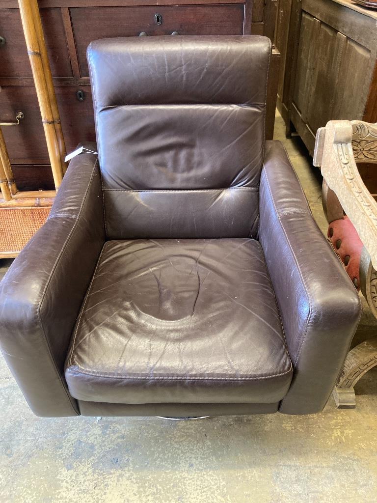 An Italian brown leather swivel armchair and two cushions, width 78cm, depth 80cm, height 91cm